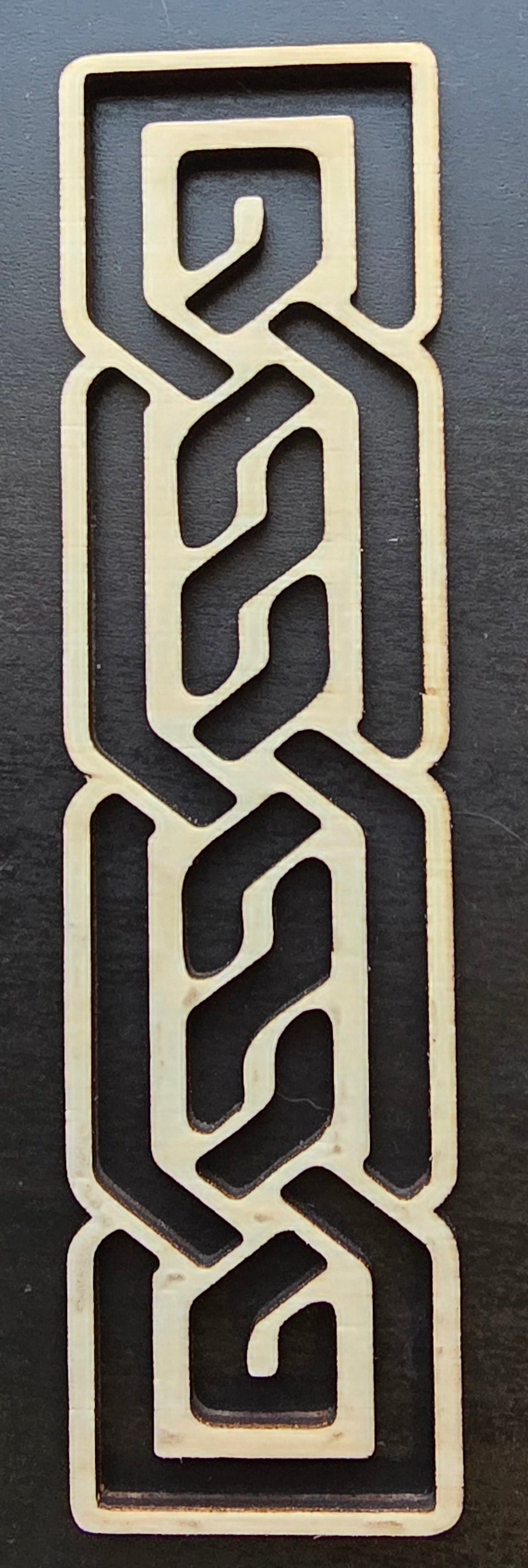 A laser engraved wooden bookmark with a Celtic knotwork design.