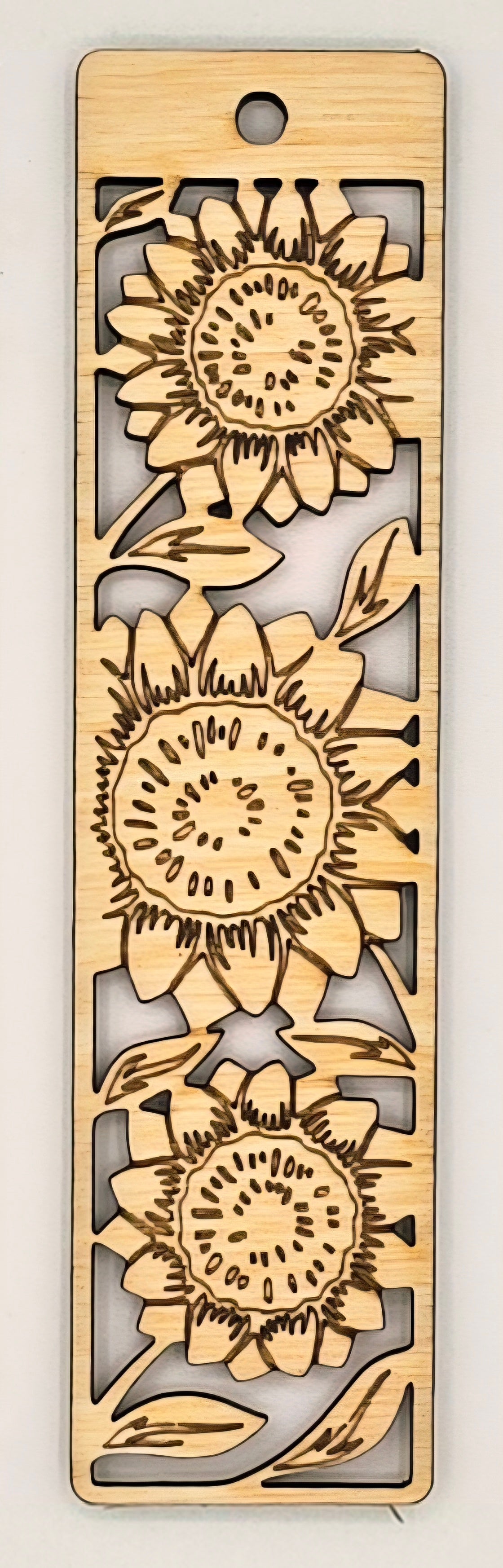 Wooden bookmark with sunflower designs on a light gray background