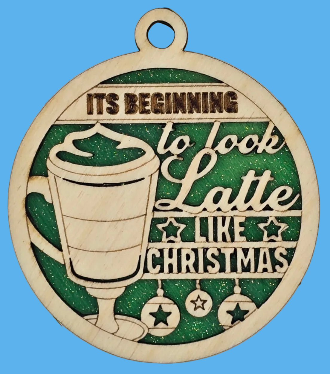 Decorative ornament with a latte illustration and Christmas text on a green background