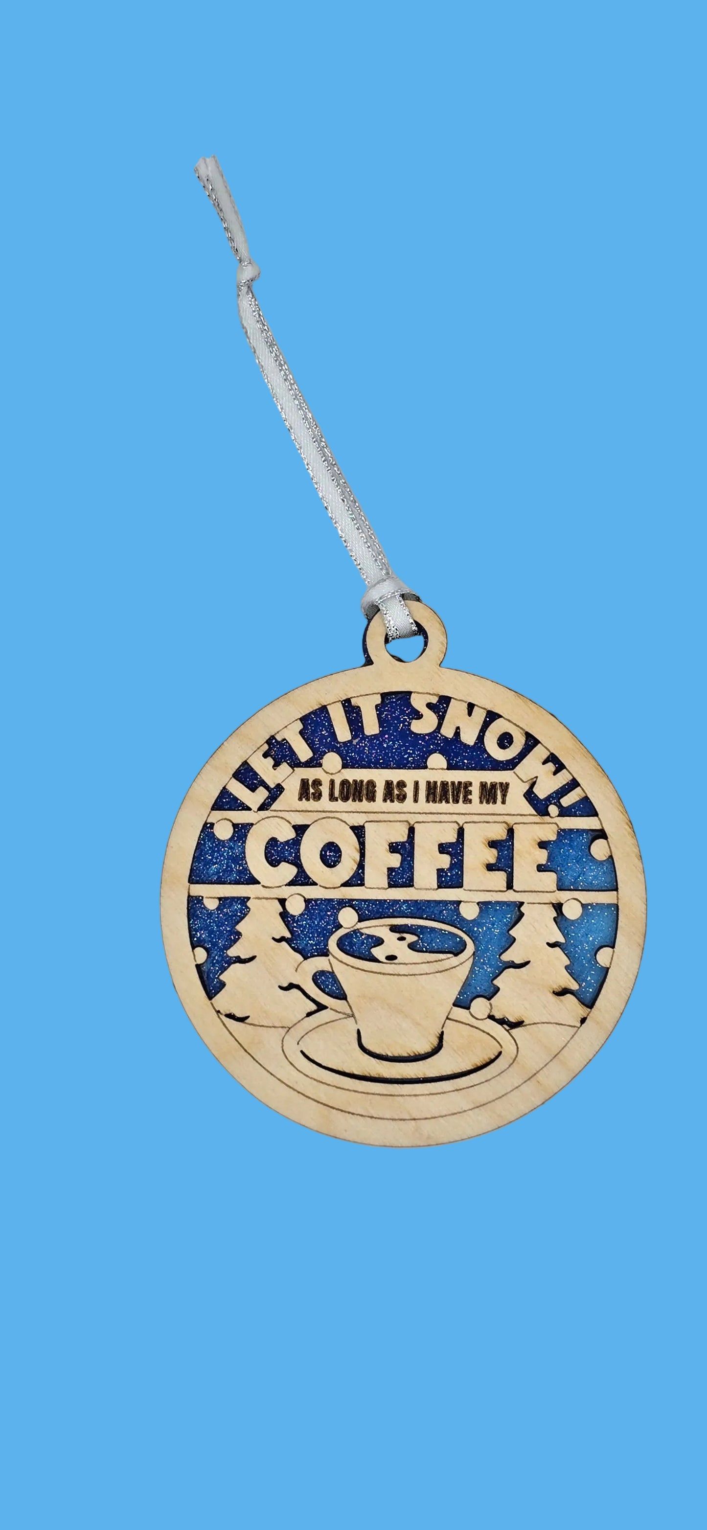 Decorative ornament with 'It's Snowin' Coffee' text on a light gray background