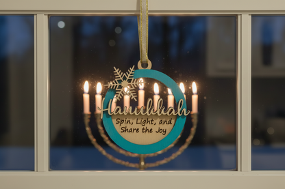 Decorative ornament with 'Hanukkah' text hanging in front of a window with lit candles.