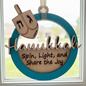 Decorative Hanukkah ornament with dreidel and text 'Hanukkah Spin, Light, and Share the Joy' on a blue circular background.
