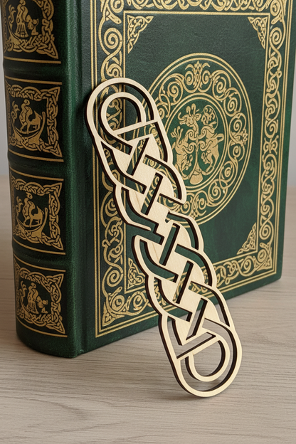 Decorative wooden bookmark with intricate design on a green book with gold embossed patterns.