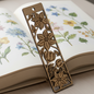 Wooden floral bookmark on an open book with botanical illustrations