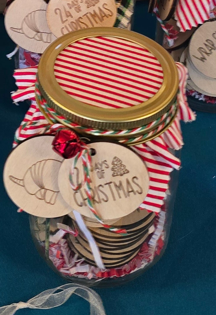 Decorative jar with Christmas-themed tags and ribbons on a blue background