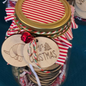 Decorative jar with Christmas-themed tags and ribbons on a blue background
