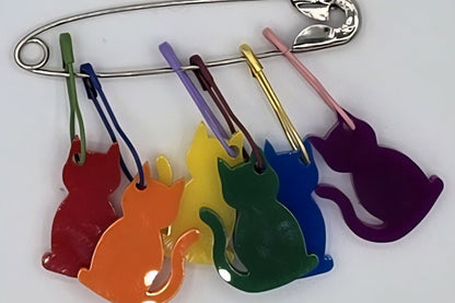 Colorful cat-shaped pins on a white background