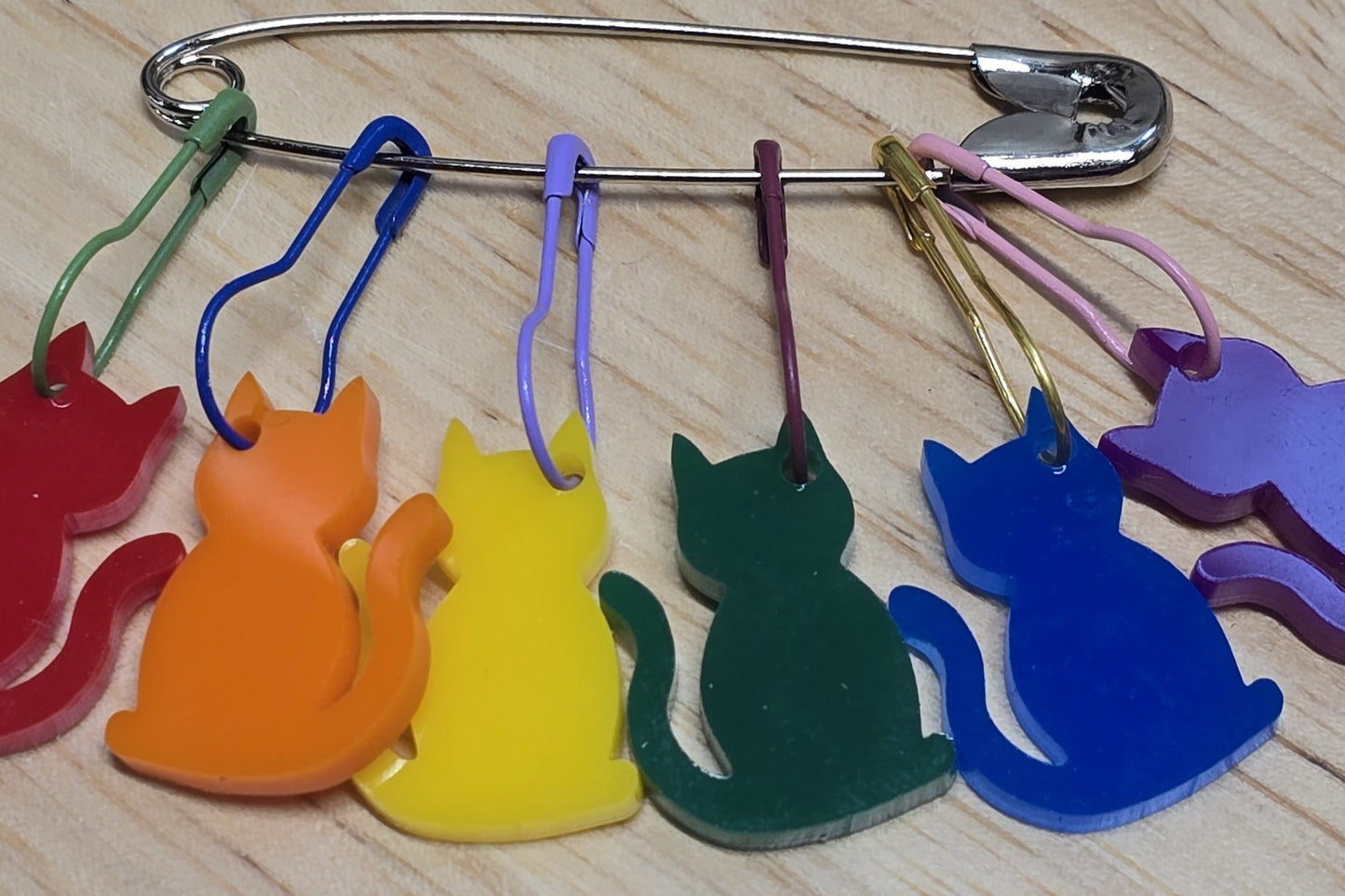 Colorful cat-shaped keychains on a wooden surface