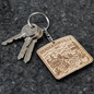 Keychain with Hendersonville, NC design featuring a mountain scene and text.