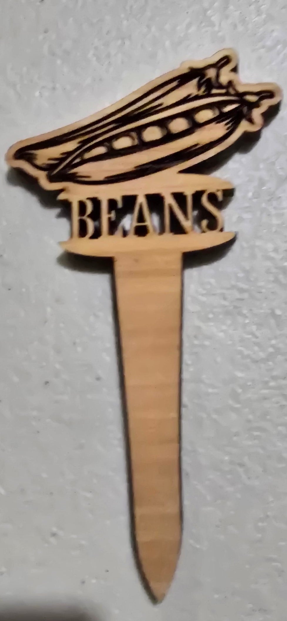 Wooden toothpick with decorative design on a plain background
