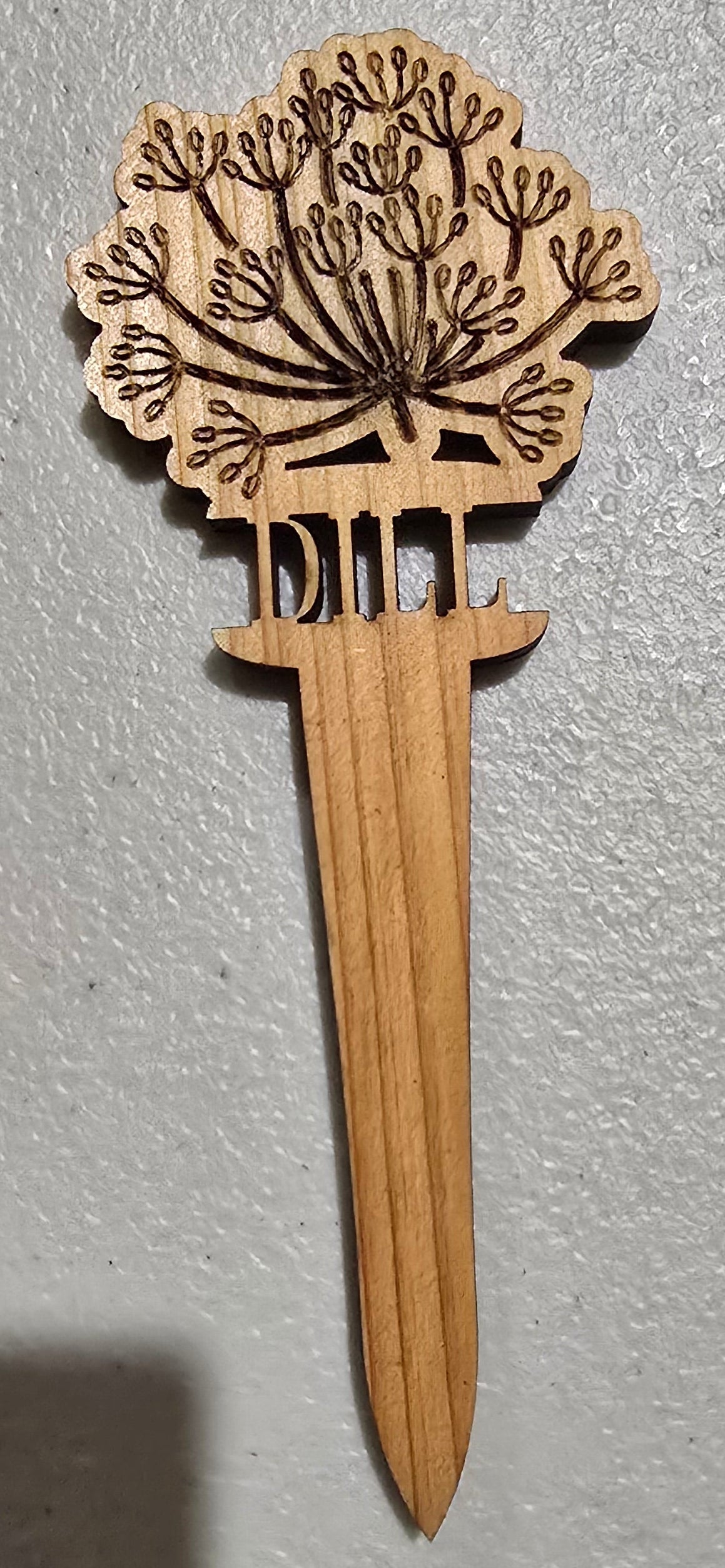 Wooden letter opener with decorative handle on a gray surface