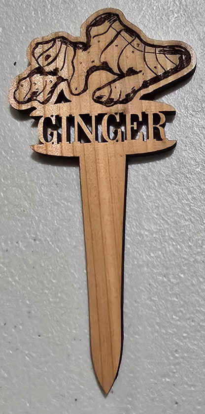Wooden stake with a laser-cut design on a light gray background