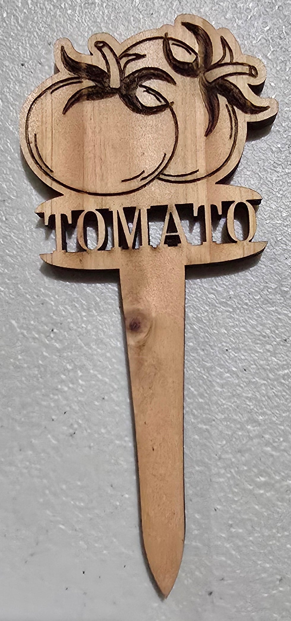 Wooden paddle with palm tree design and text on a light gray surface