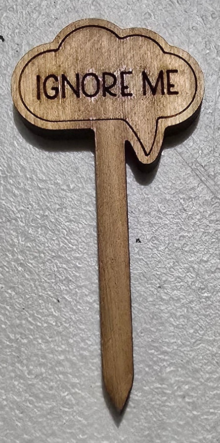 Wooden toothpick with 'IGNORE ME' text on a white surface