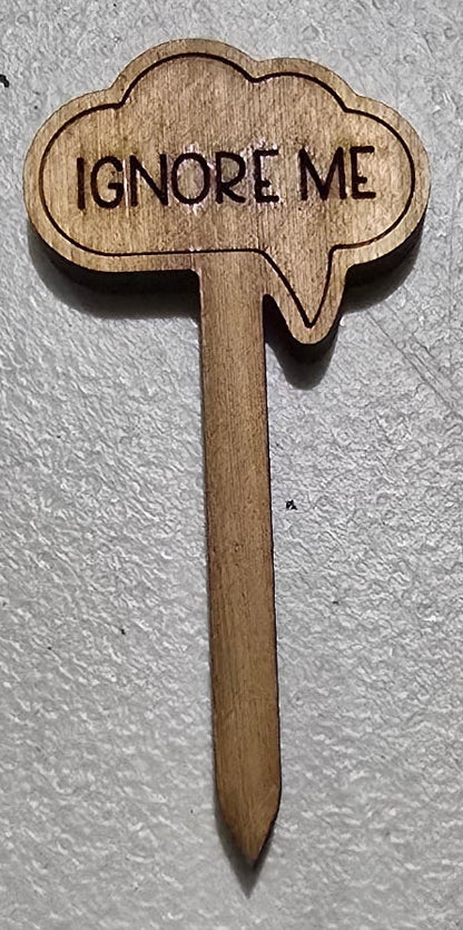 Wooden toothpick with 'IGNORE ME' text on a white surface