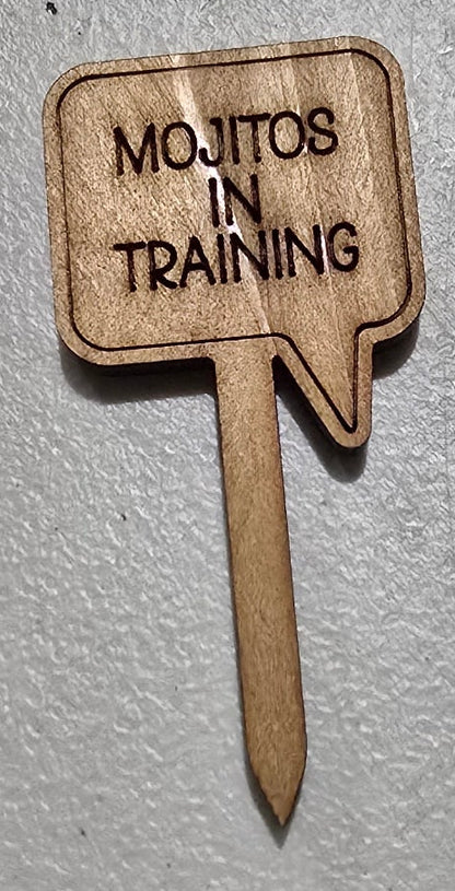 Wooden sign with 'Mojitos in Training Training' text on a light gray background