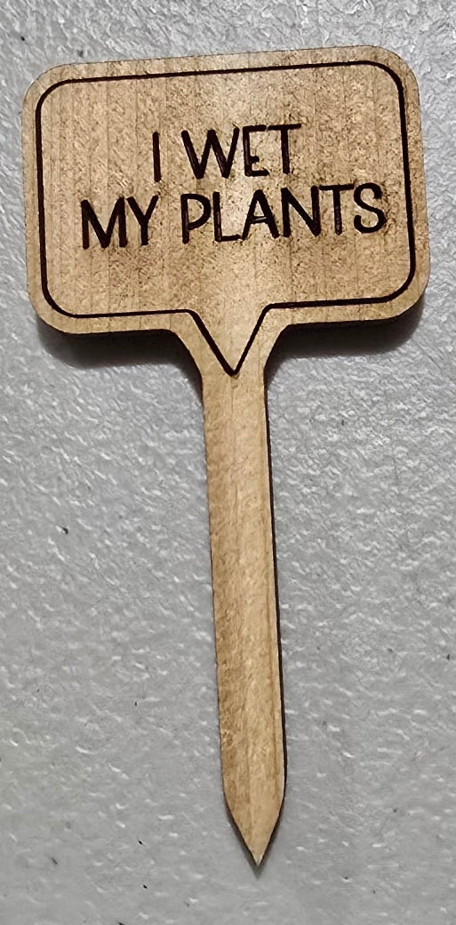 Wooden plant label with 'I wet my plants' text on a gray background