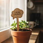 Potted plant with a wooden sign that says 'Grow Dammit!' in a home setting.