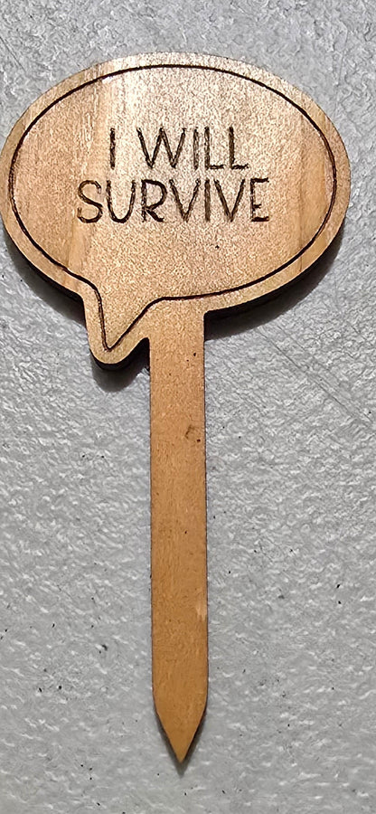 Wooden pick with 'I will survive' text on a gray surface