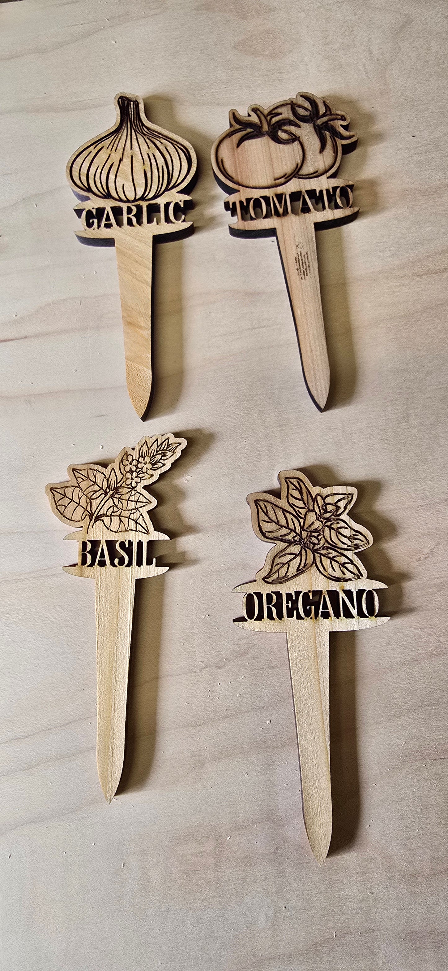 Set of wooden herb markers with plant illustrations and text on a wooden surface