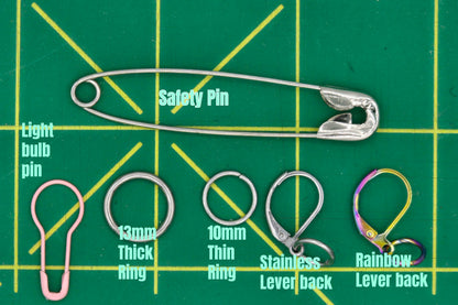 Collection of various types of pins on a green grid background