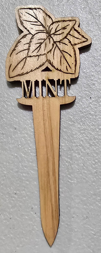 Wooden mint plant marker design on a gray surface
